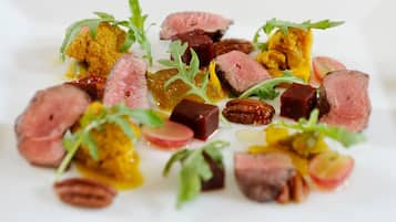 A dish with various food items including meat, vegetables, and nuts.