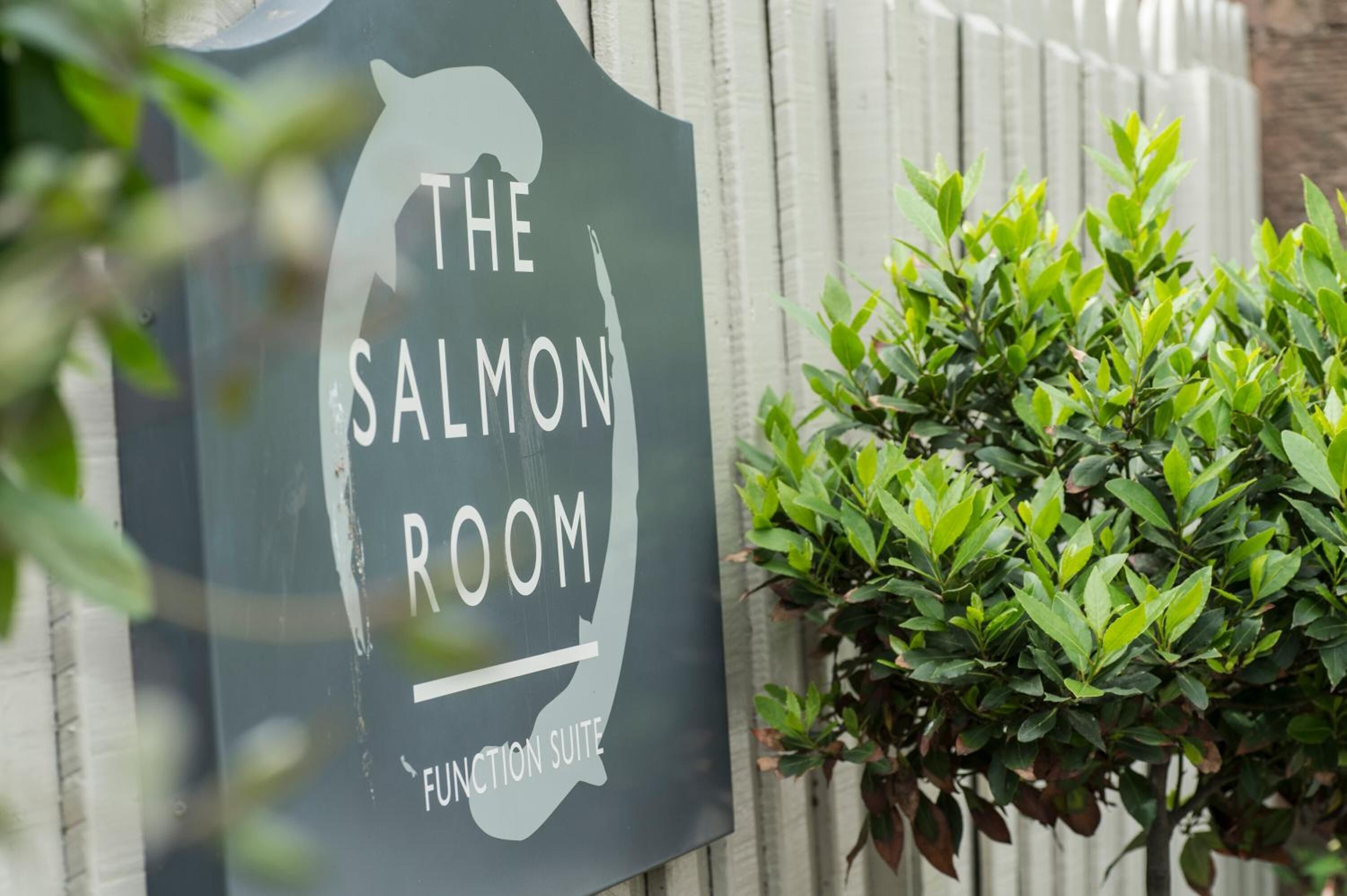 Letrero que dice "The Salmon Room Function Suite" con la silueta de un salmón y una montaña al fondo.