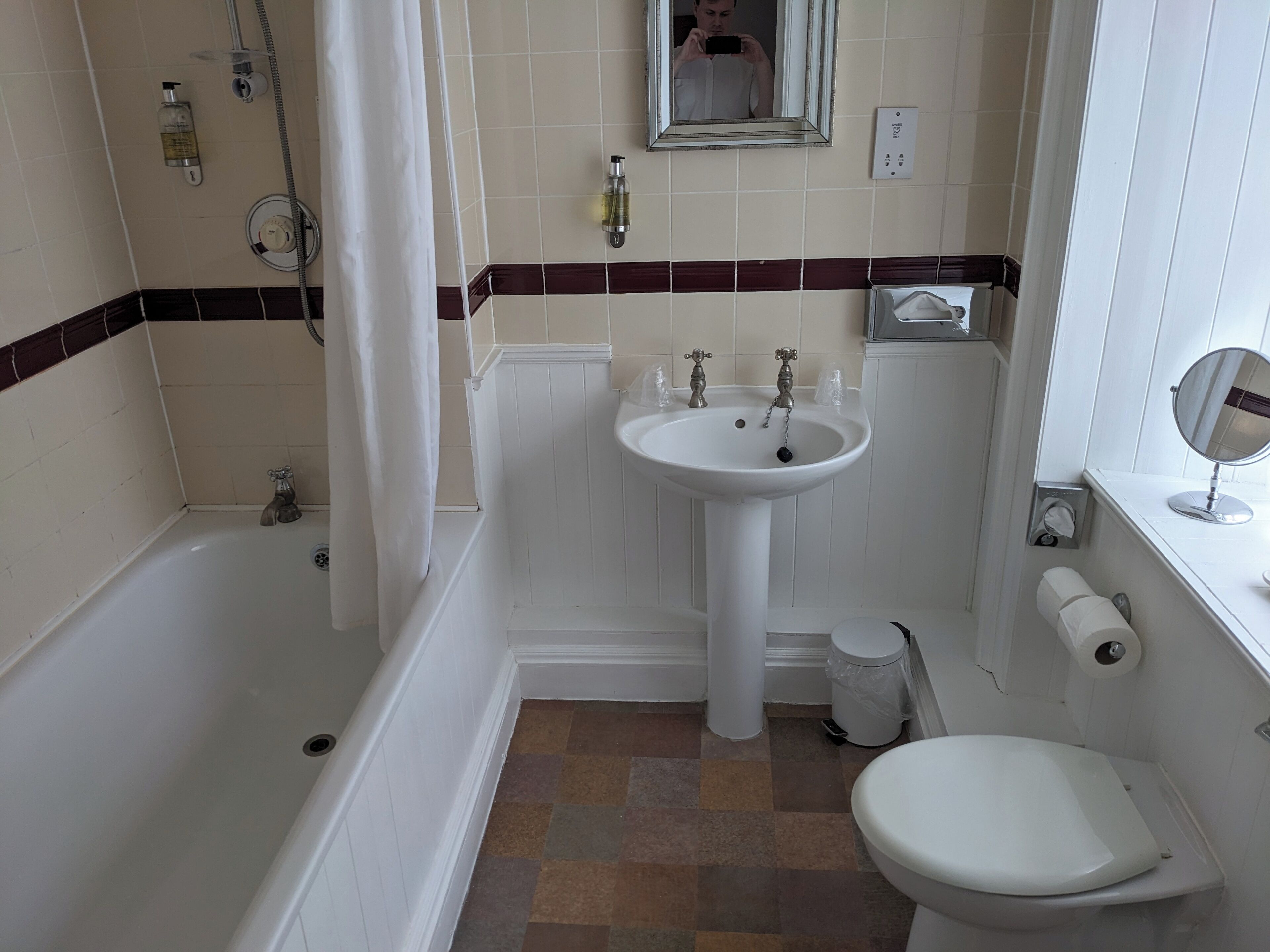 A bathroom with a bathtub, sink, toilet, and a mirror.