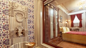 A room with a large bed, a wooden cabinet, and a decorative wall panel. - Dersaadet Hotel - Special Class (Istanbul)