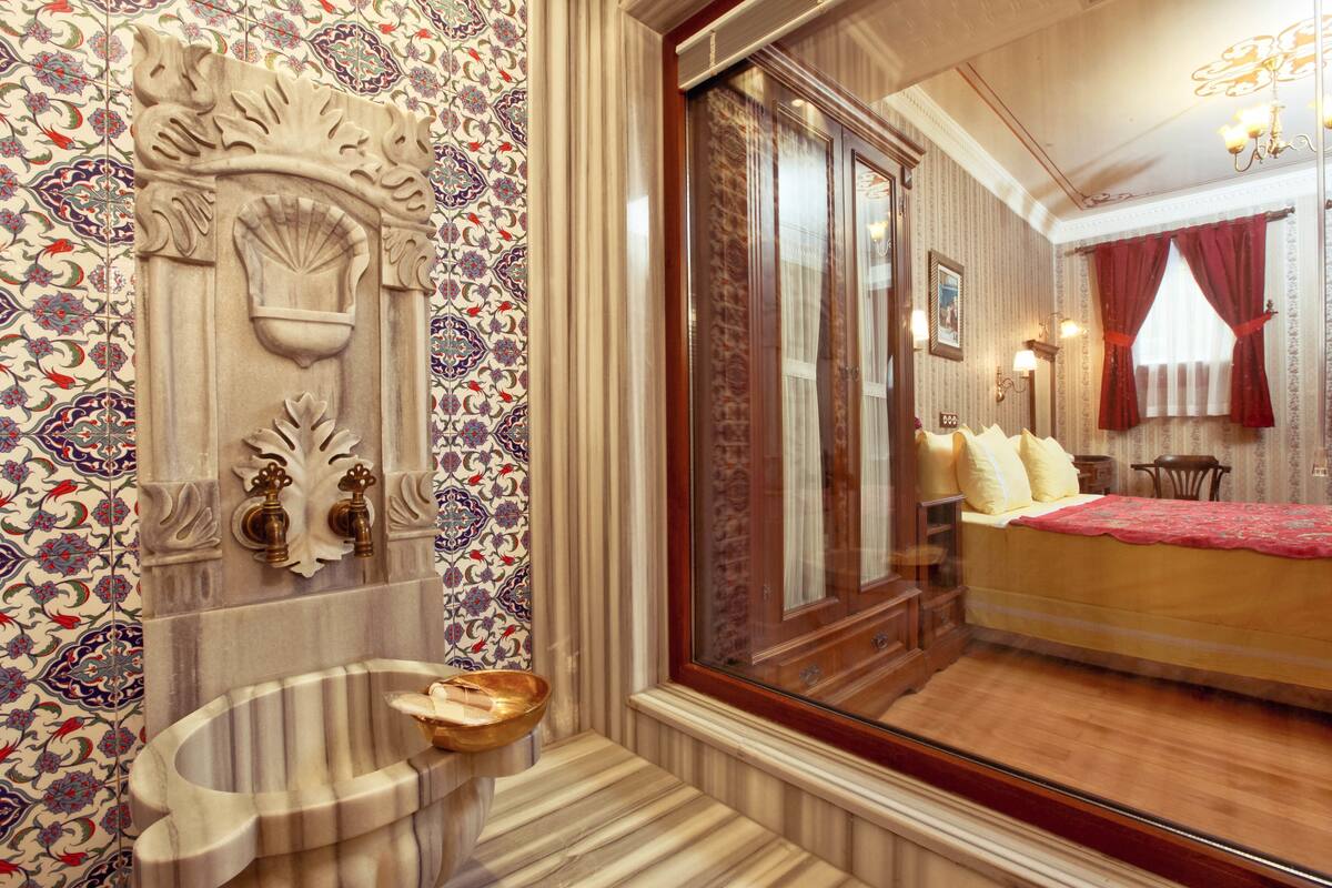 A room with a large bed, a wooden cabinet, and a decorative wall panel.