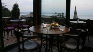 A terrace with round tables and chairs, a fruit bowl, and glasses. - Dersaadet Hotel - Special Class (Istanbul)