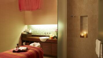 A modern bathroom with a large sink, a mirror, and a shower area.