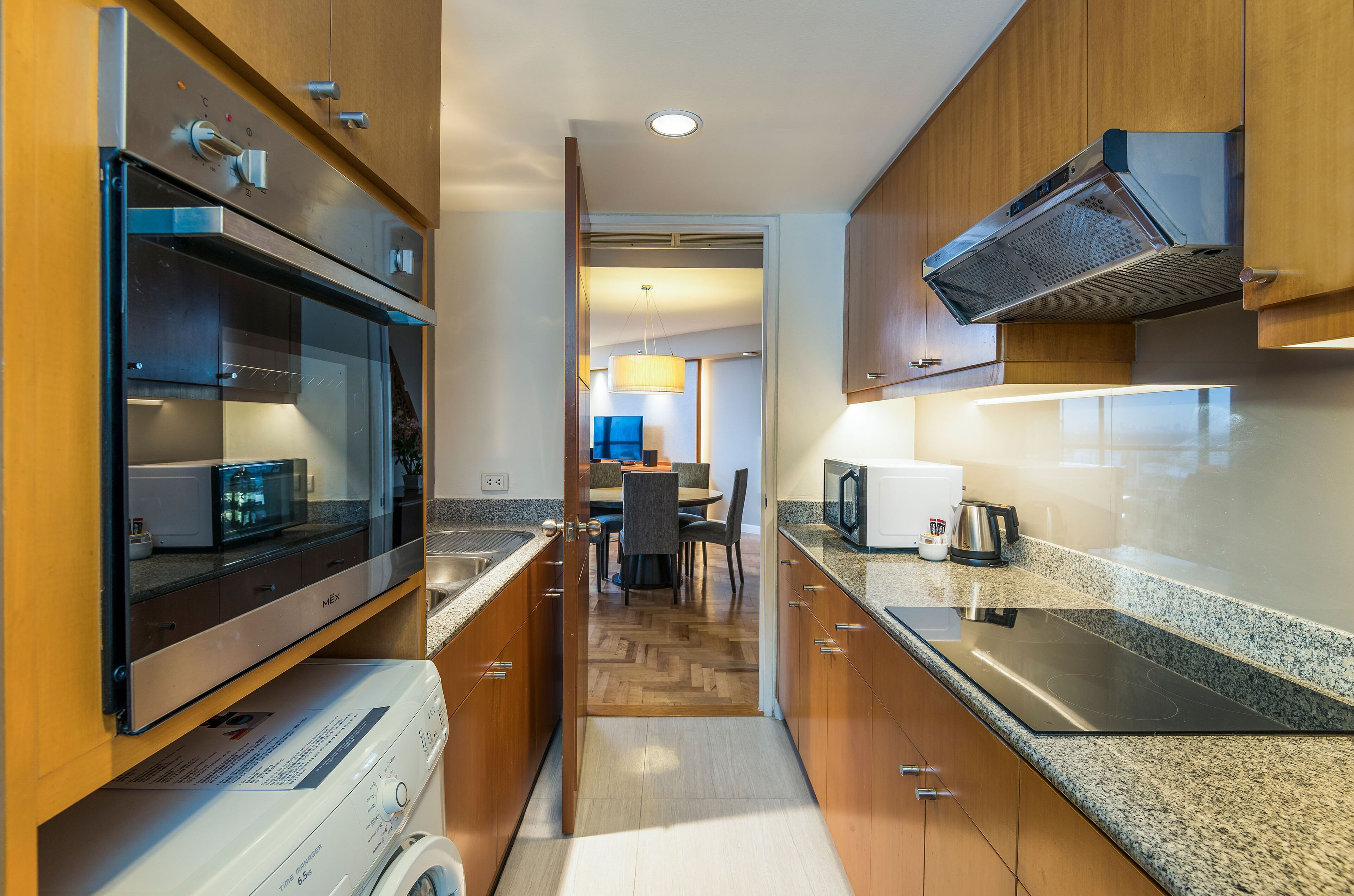 Una cocina moderna con electrodomésticos integrados, armarios de madera y una isla central.