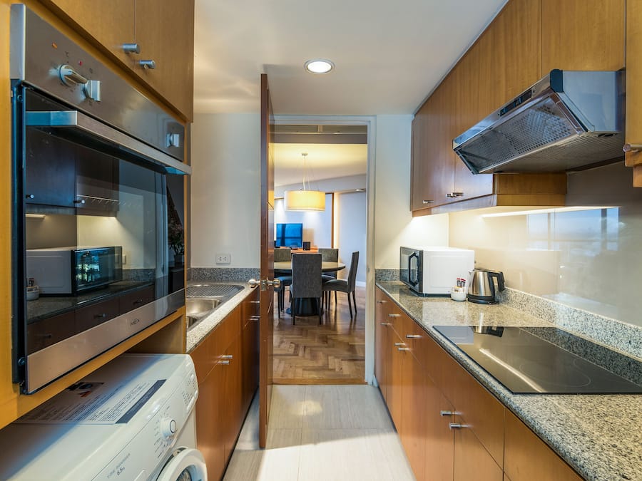 Una cocina moderna con electrodomésticos integrados, armarios de madera y una isla central.