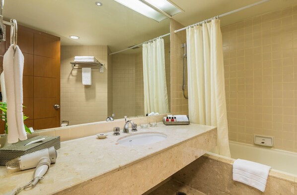 Un baño con lavamanos, espejo, toallero y cortina de ducha.