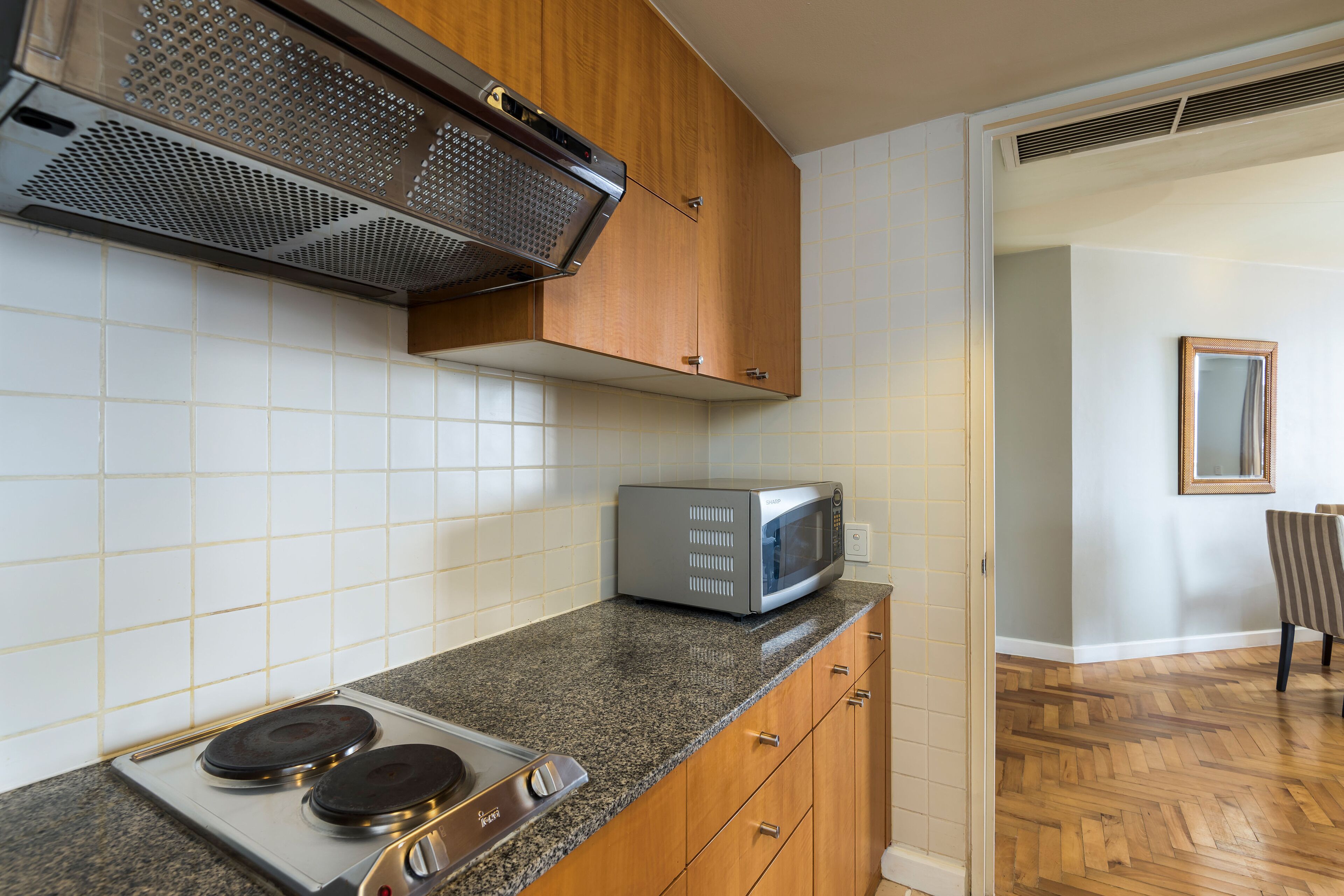 A kitchen with a microwave, stove, and wooden cabinets.