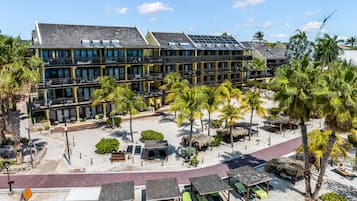 A hotel with multiple floors, outdoor seating areas, and a beachside location.