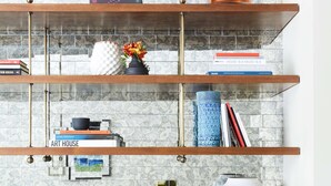 A kitchen with a marble backsplash, wooden shelves with books and decorative items, and a wooden cabinet with a glass countertop. - The Laurel Inn, part of JdV by Hyatt (San Francisco)