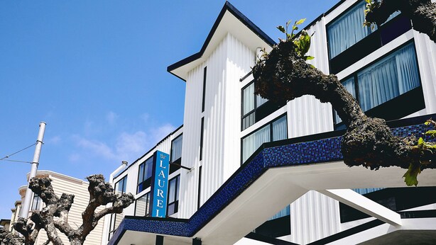 A modern hotel with a prominent 'LAUREL' sign, featuring a white facade with blue accents and a unique architectural design. - The Laurel Inn, part of JdV by Hyatt (San Francisco)