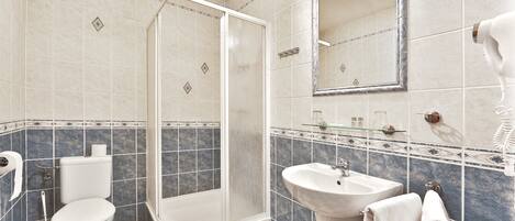 Un baño con inodoro, lavabo y ducha.