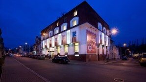 Un hotel de varios pisos con ventanas iluminadas y un anuncio llamativo en la fachada.