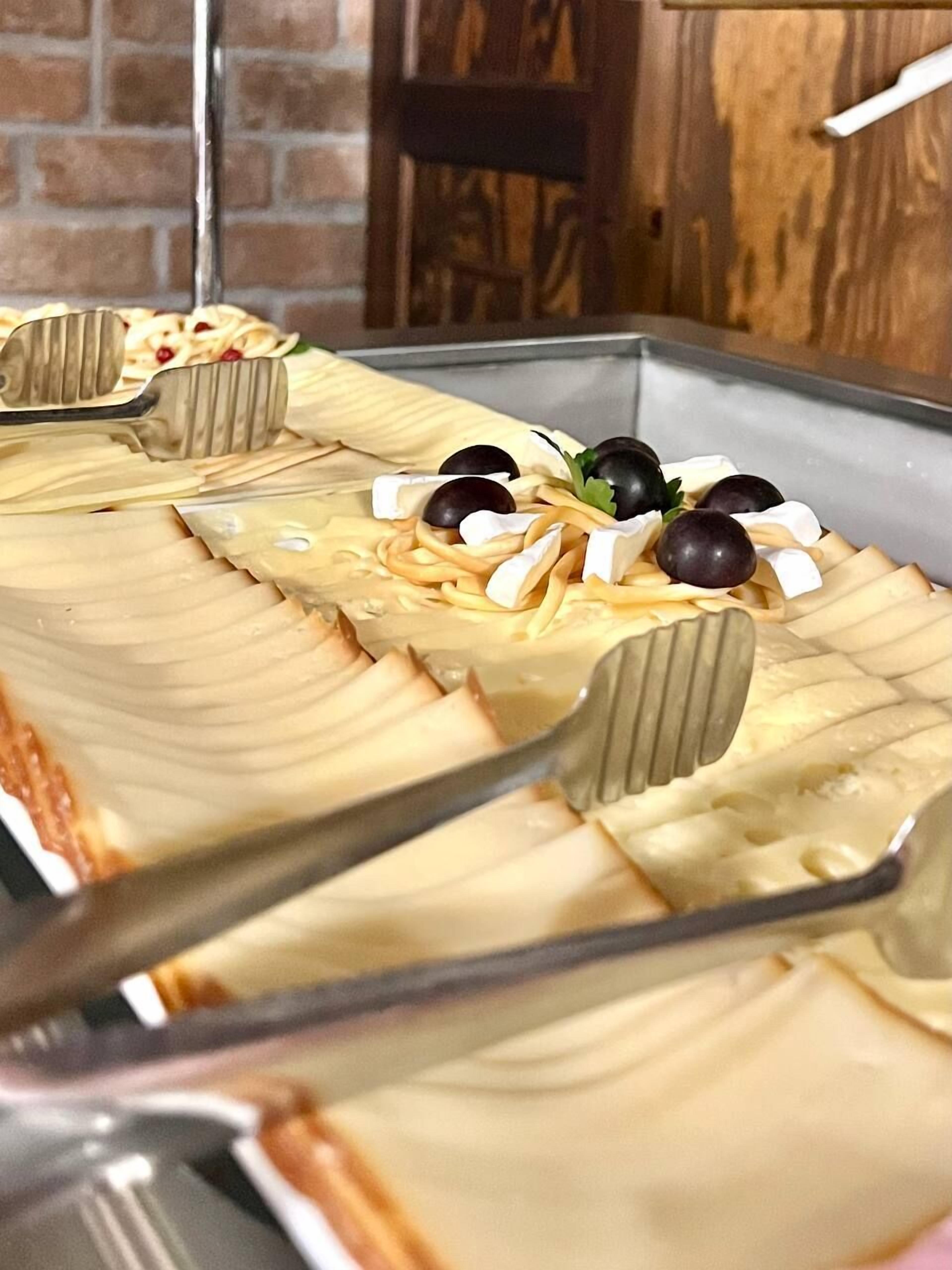 Un plateau de fromages accompagné de crackers et d’olives.