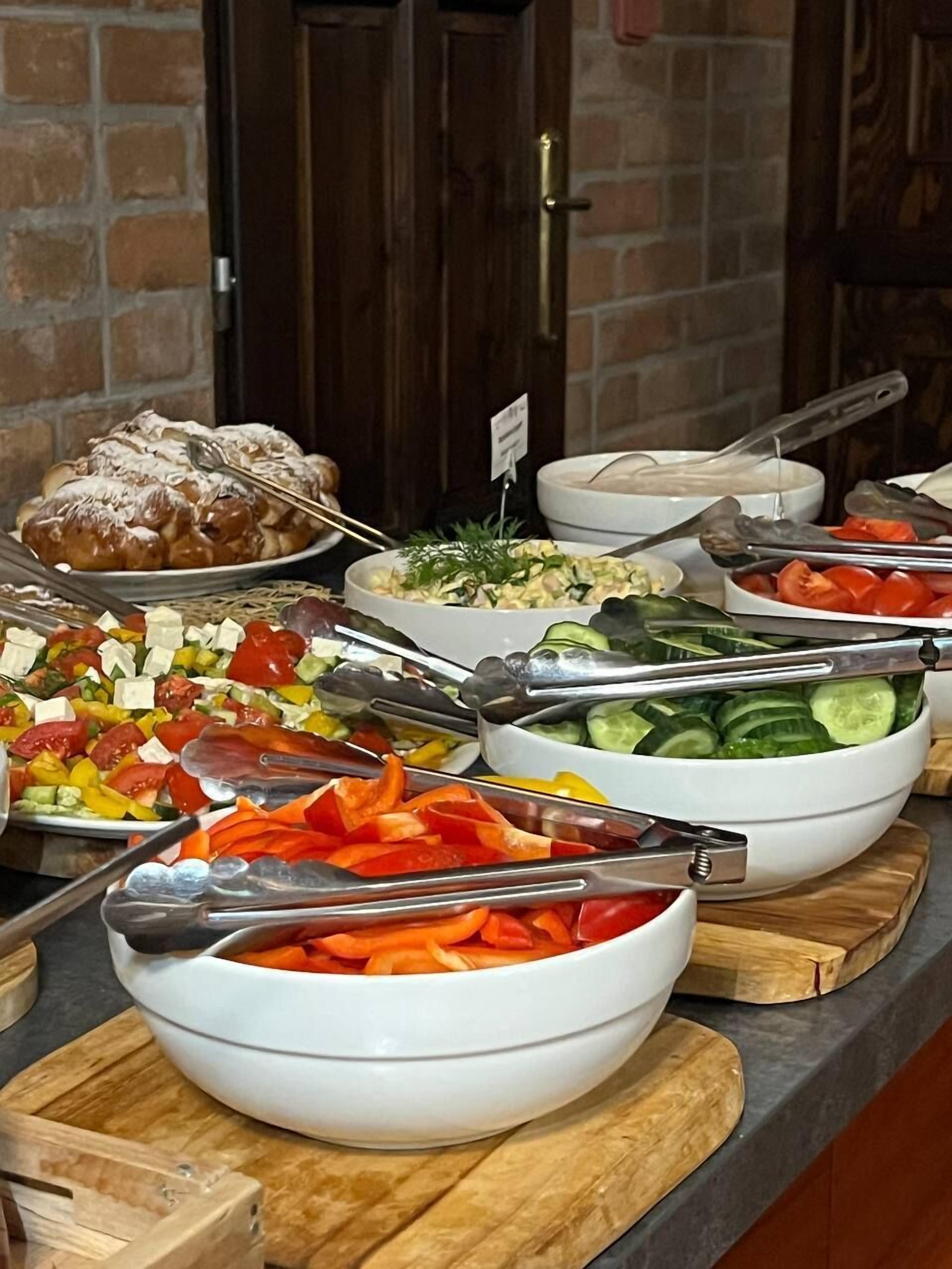 Un bufé con diversos alimentos y utensilios de servicio.