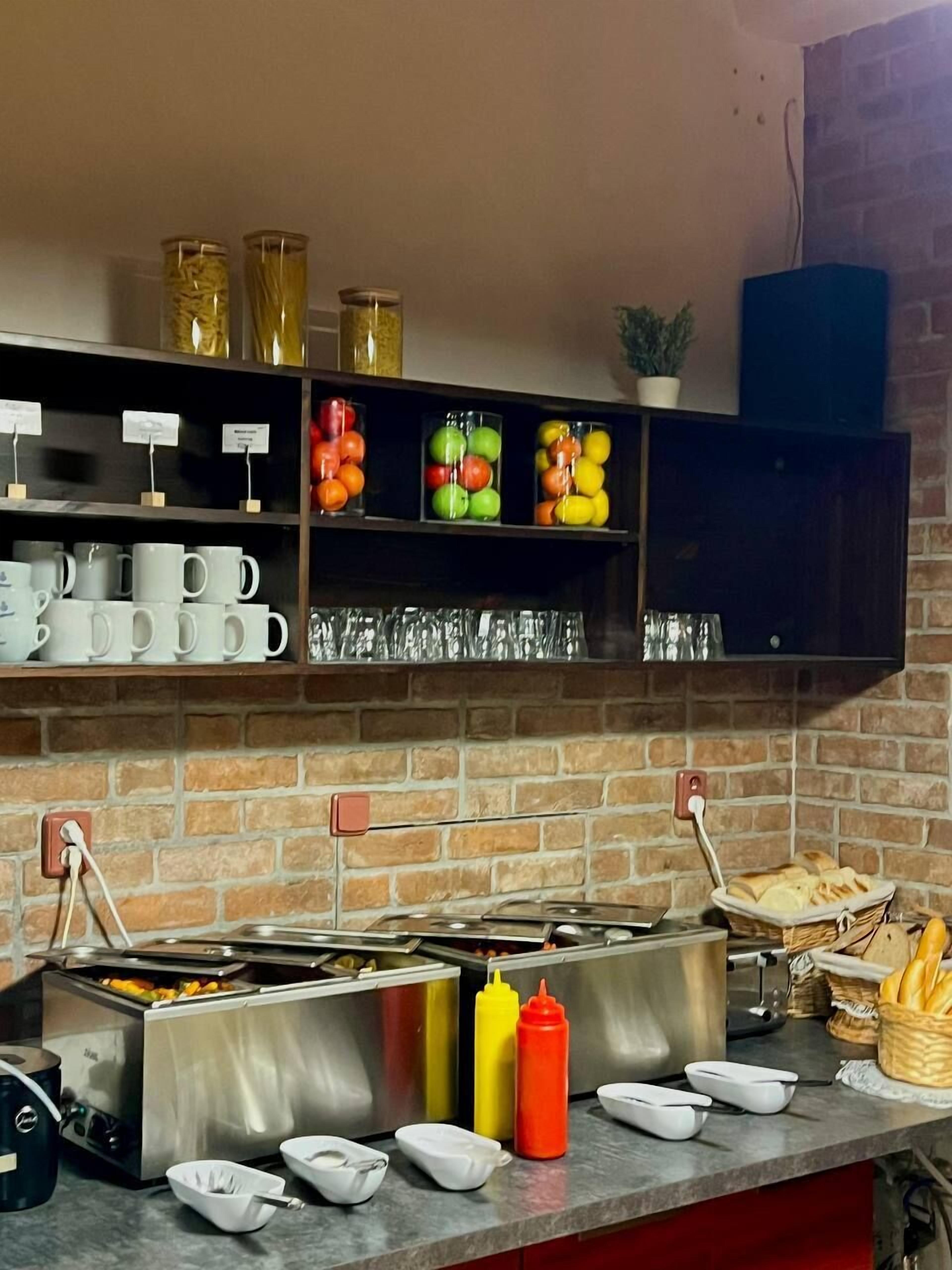 Una barra de desayuno con diversos alimentos, botellas de condimentos y un fondo de pared de ladrillo.