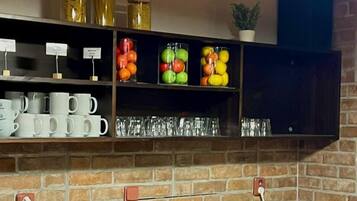 Una barra de desayuno con diversos alimentos, botellas de condimentos y un fondo de pared de ladrillo.