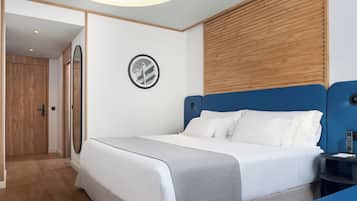 A modern hotel room with a bed, bedside table, and a circular wall decoration.