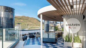 A modern outdoor lounge area with a pool, seating, and a sign reading "BHEAVEN Macusamba". - Barceló Santa Cruz Contemporáneo (Santa Cruz de Tenerife)