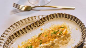 Un plato con base cremosa, decorado con hierbas y ralladura de limón.