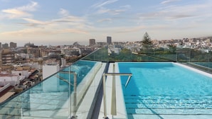 A rooftop infinity pool with a city view, glass railings, and a clear sky. - Barceló Santa Cruz Contemporáneo (Santa Cruz de Tenerife)