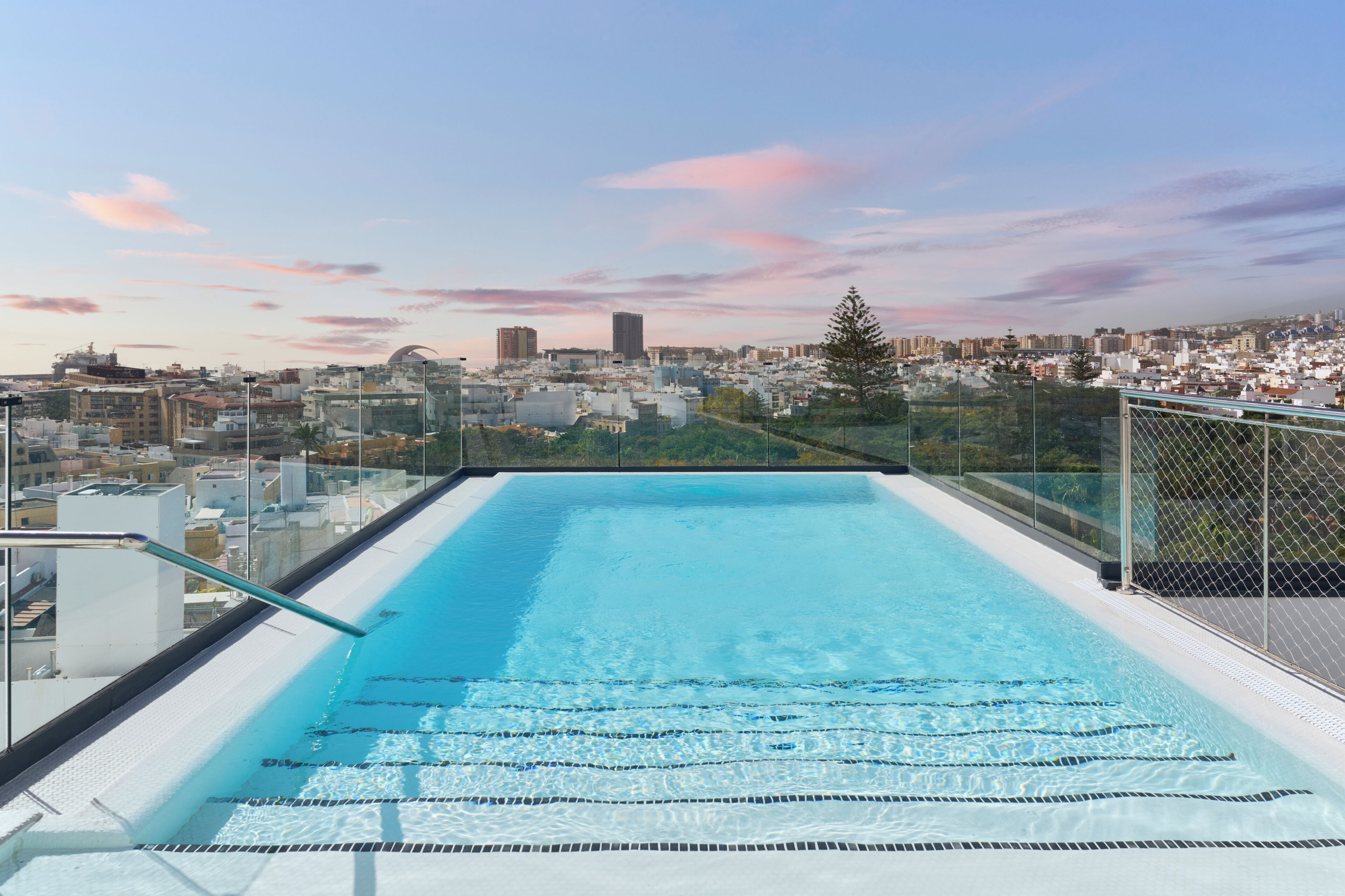 Una piscina al aire libre, sombrillas, tumbonas