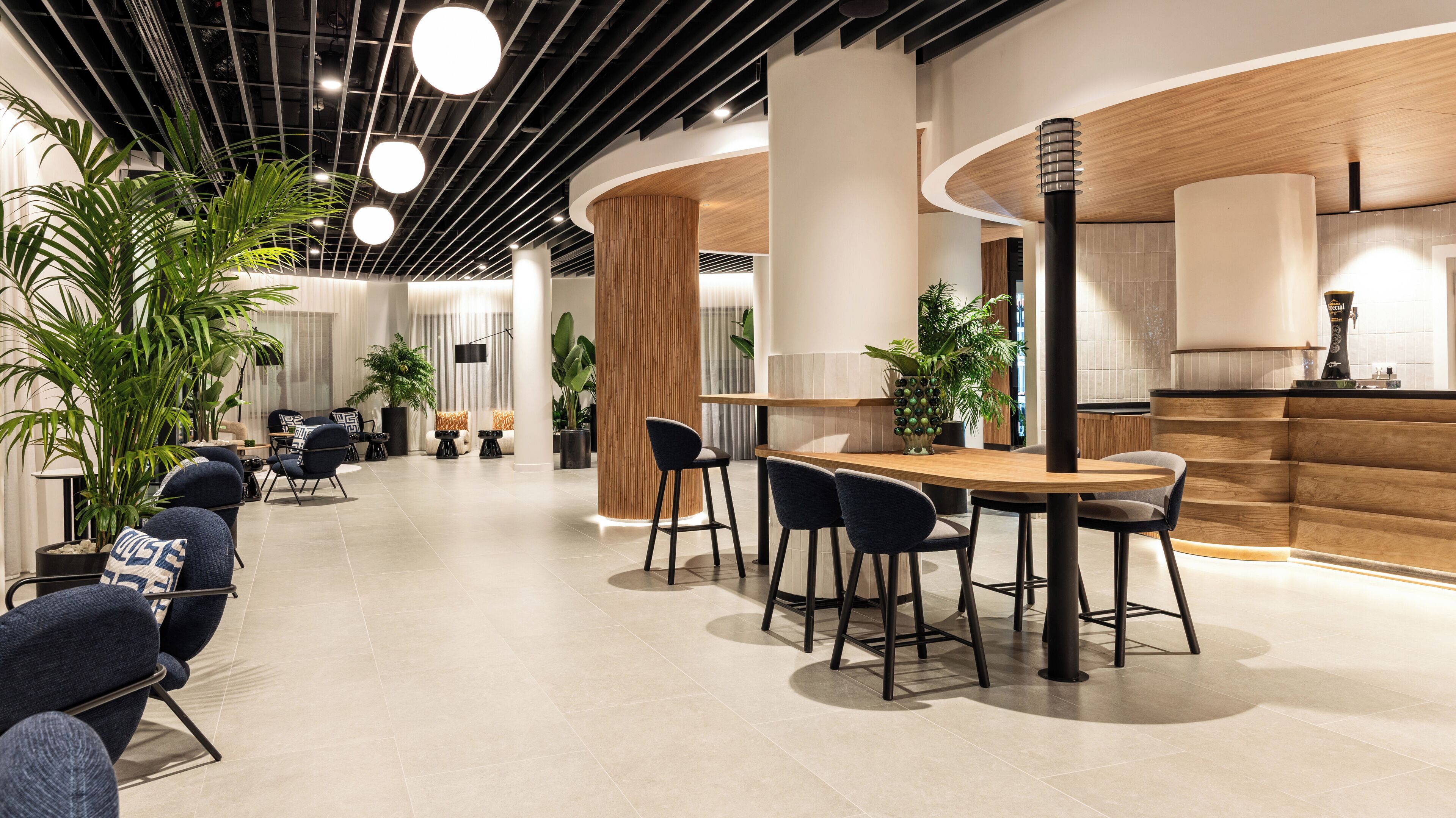 A modern interior with a reception desk, seating area, and a kitchen.