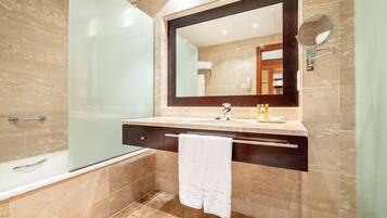 A modern bathroom with a glass-enclosed shower, a large mirror, and a towel hanging on the wall.