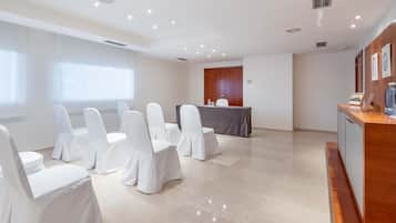 Meetings take place in this well-appointed conference room with a long table and comfortable seating.