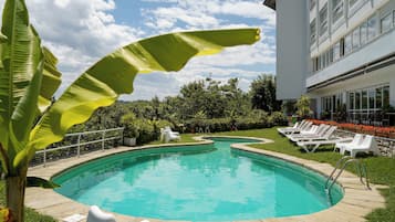 Una piscina al aire libre, tumbonas