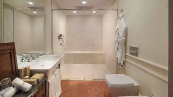 A modern bathroom with a large bathtub, a separate shower area, a vanity with a sink, and a toilet.