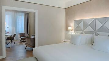 Une chambre d’hôtel avec un grand lit, un bureau avec une chaise et une vue sur l’extérieur par une porte.
