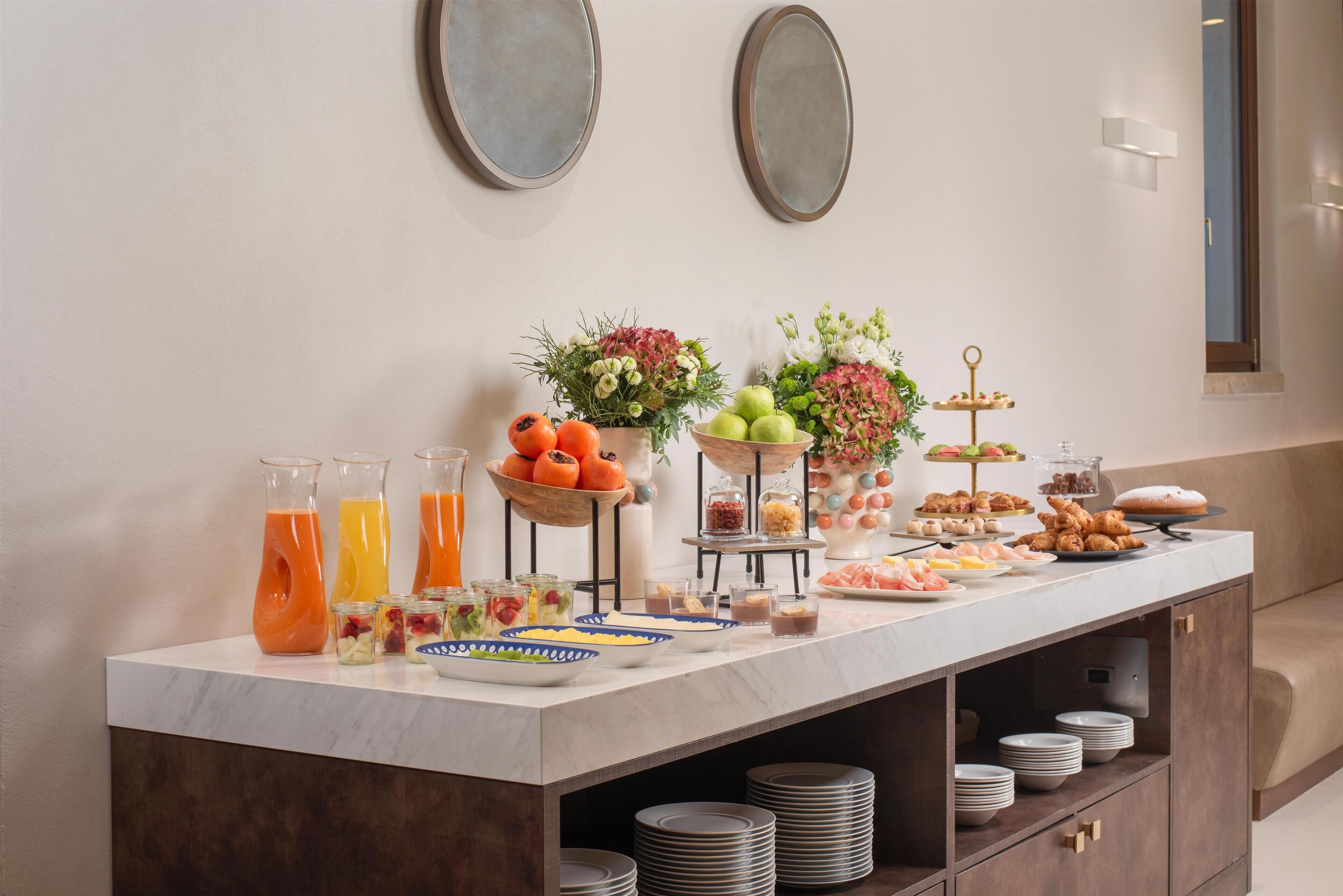 A buffet setup with various food items and drinks.