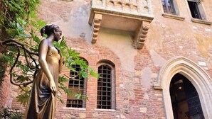 A statue of a woman in a dress, a brick building with arched windows, and a balcony with stone railings. - NH Collection Palazzo Verona (Verona)