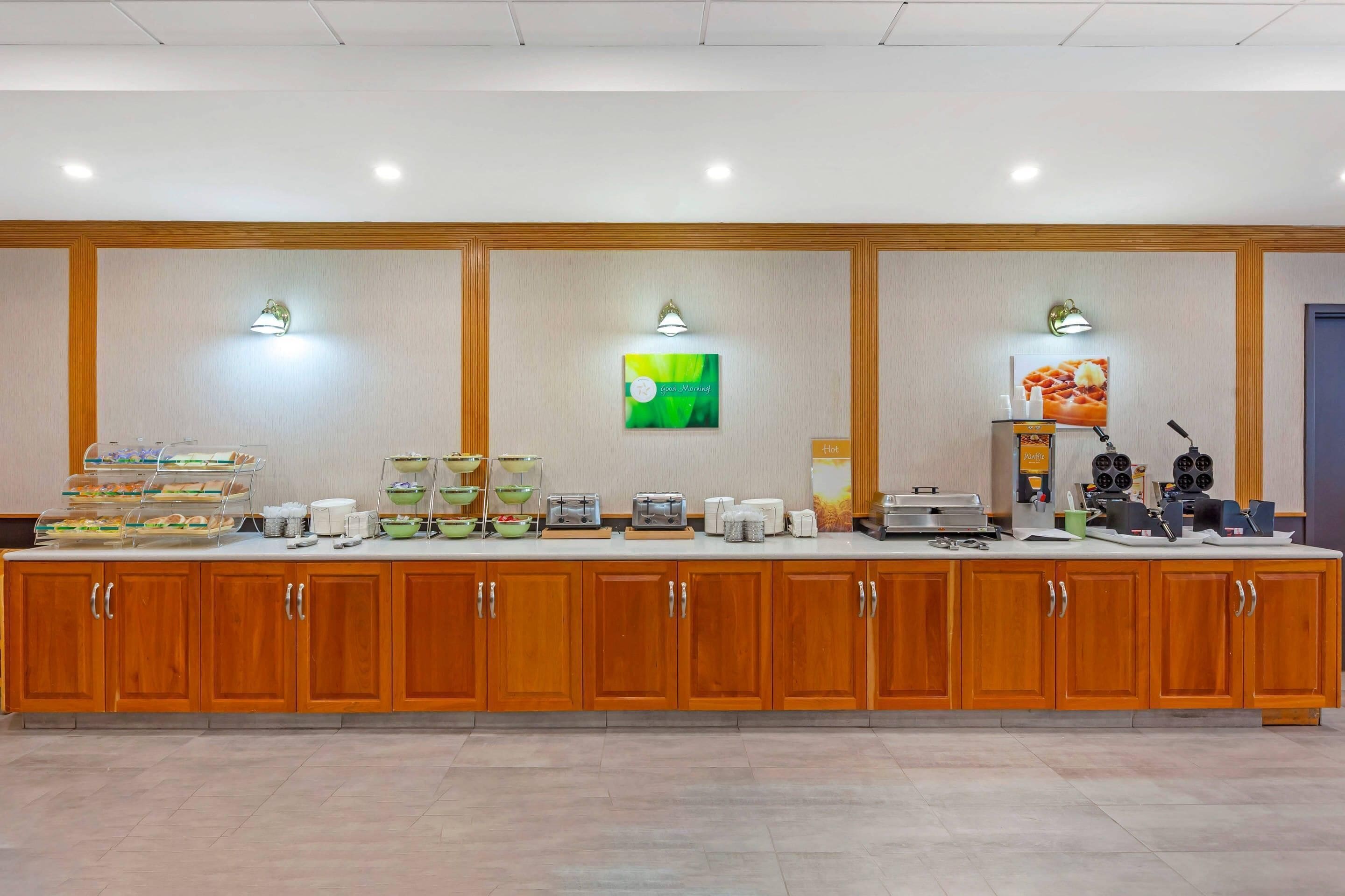 A buffet setup with food stations, a coffee machine, and a microwave.