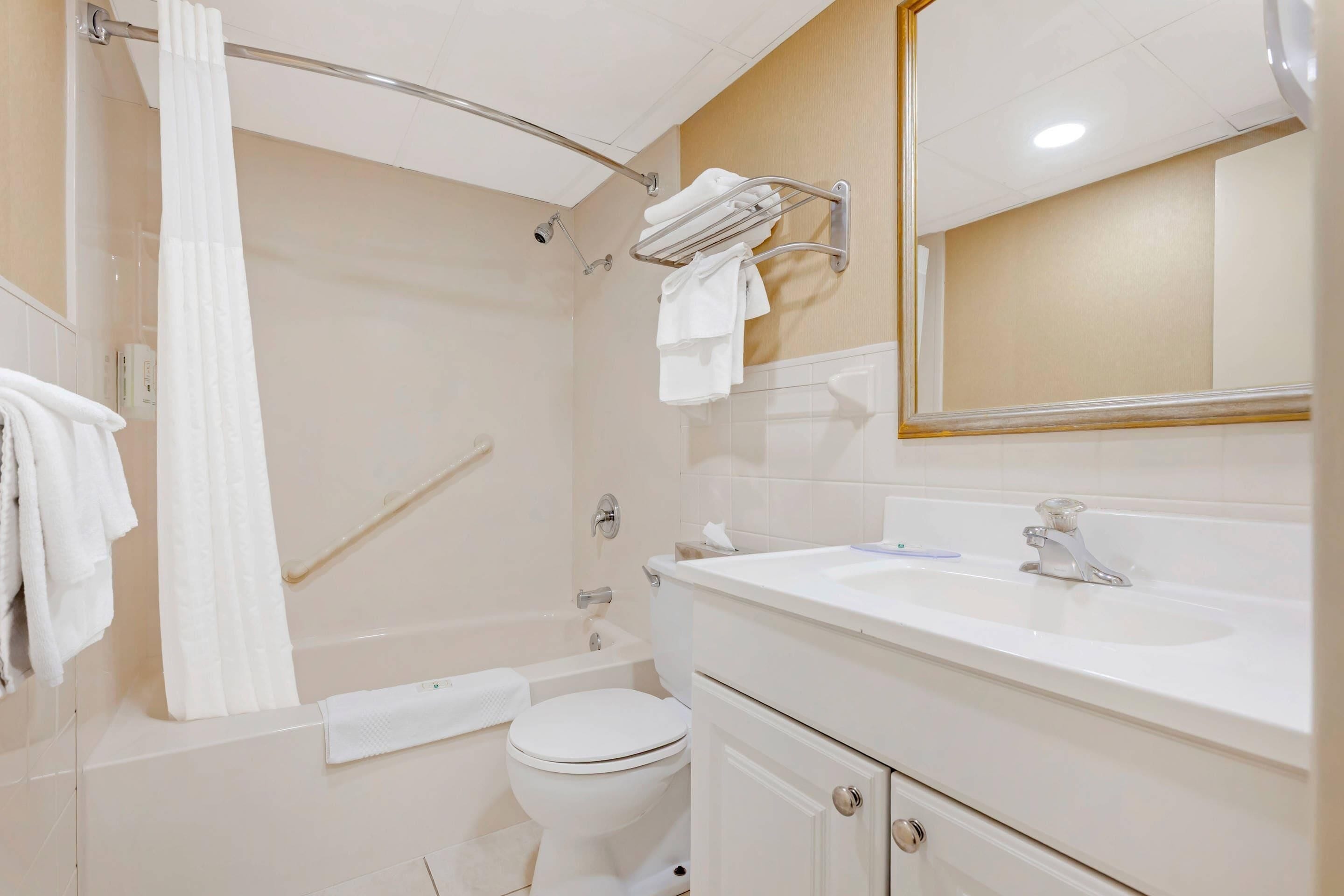 A bathroom with a bathtub, toilet, sink, and a towel rack.