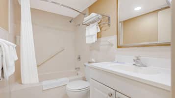 A bathroom with a bathtub, toilet, sink, and a towel rack.