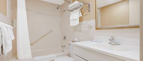 A bathroom with a bathtub, toilet, sink, and a towel rack.