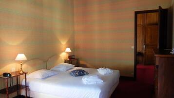 Ein Hotelzimmer mit einem Bett, zwei Nachttischlampen, einem Holzschrank und einem roten Teppich.