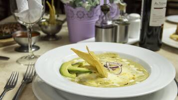 A plate of food with avocado and a tortilla chip on a white plate.