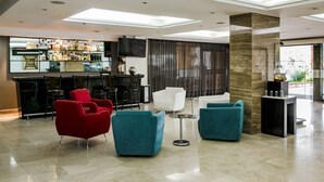 A modern lobby with a bar area, seating, and a large pillar.