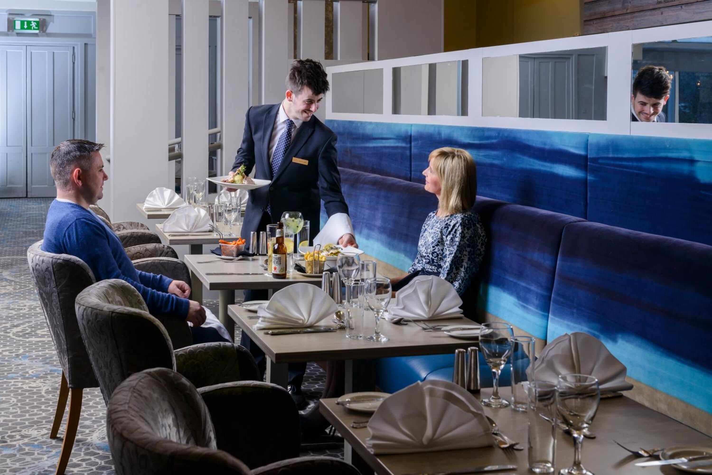 A restaurant with a modern interior, including a blue and white color scheme, comfortable seating, and a clean, well-lit environment.