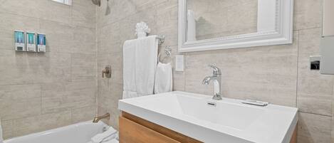A modern bathroom with a bathtub, a sink, and a mirror.
