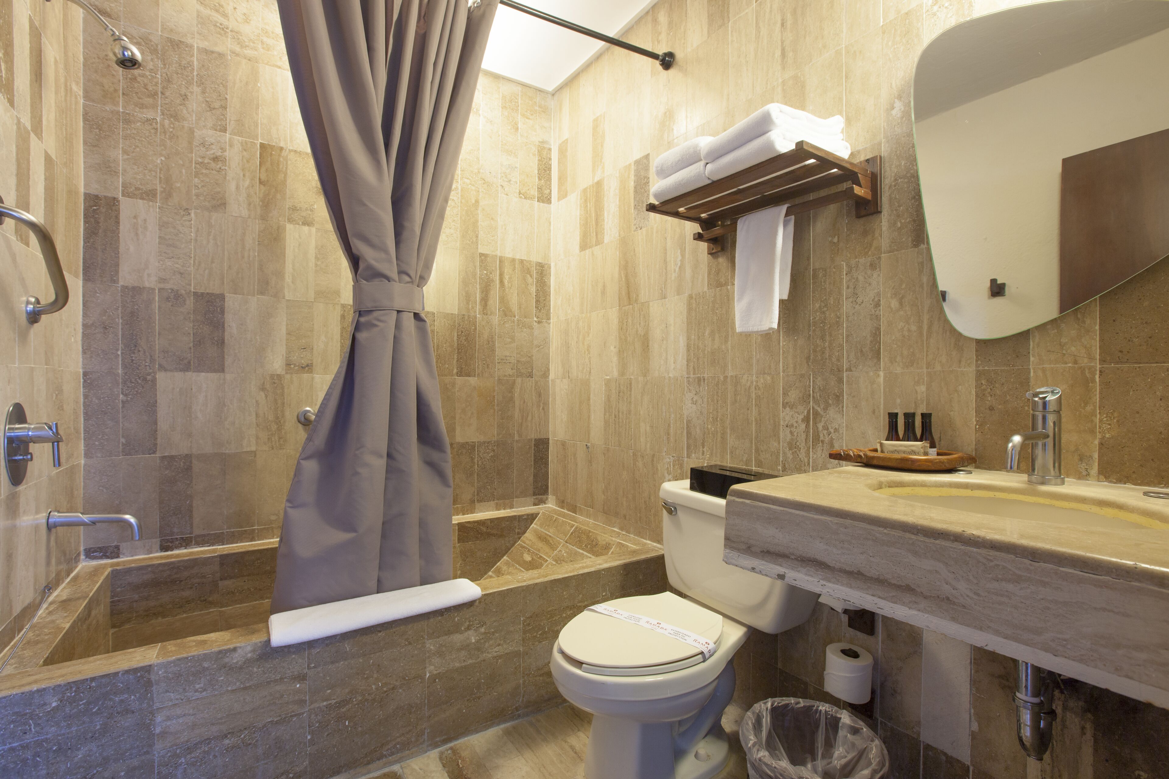 Un baño con bañera, inodoro, lavabo y cortina de ducha.