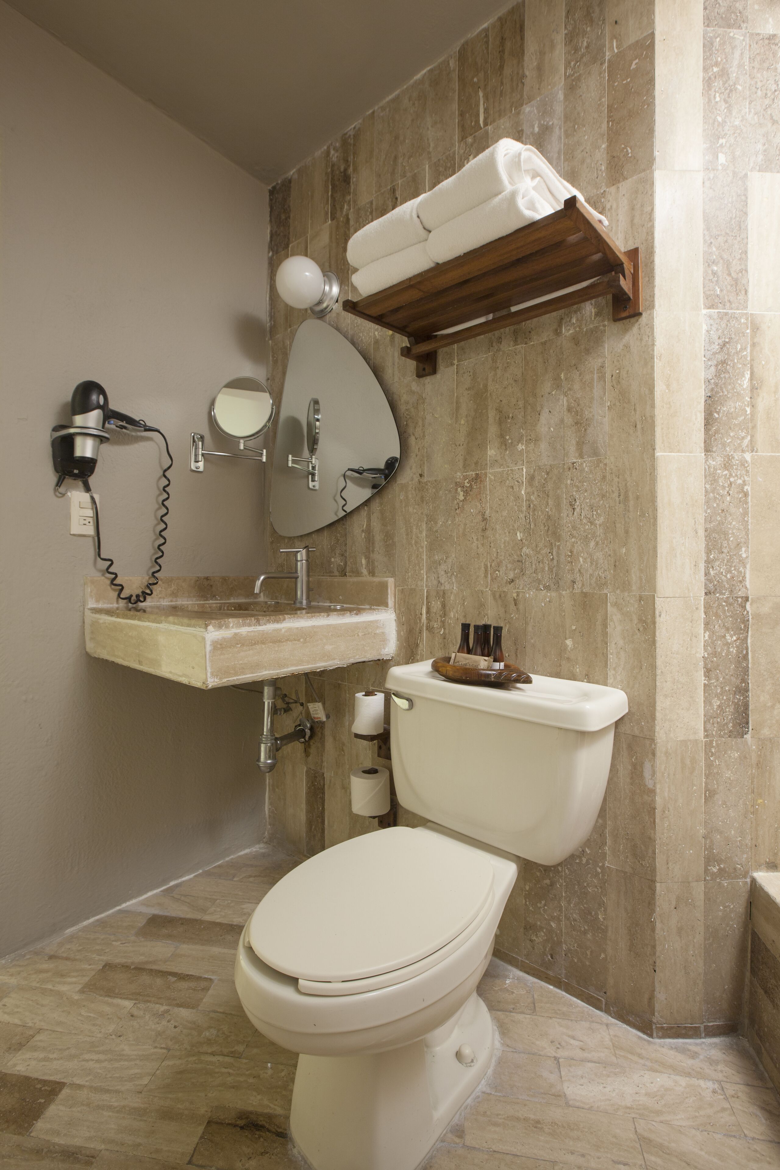 A bathroom with a toilet, sink, and towel rack.
