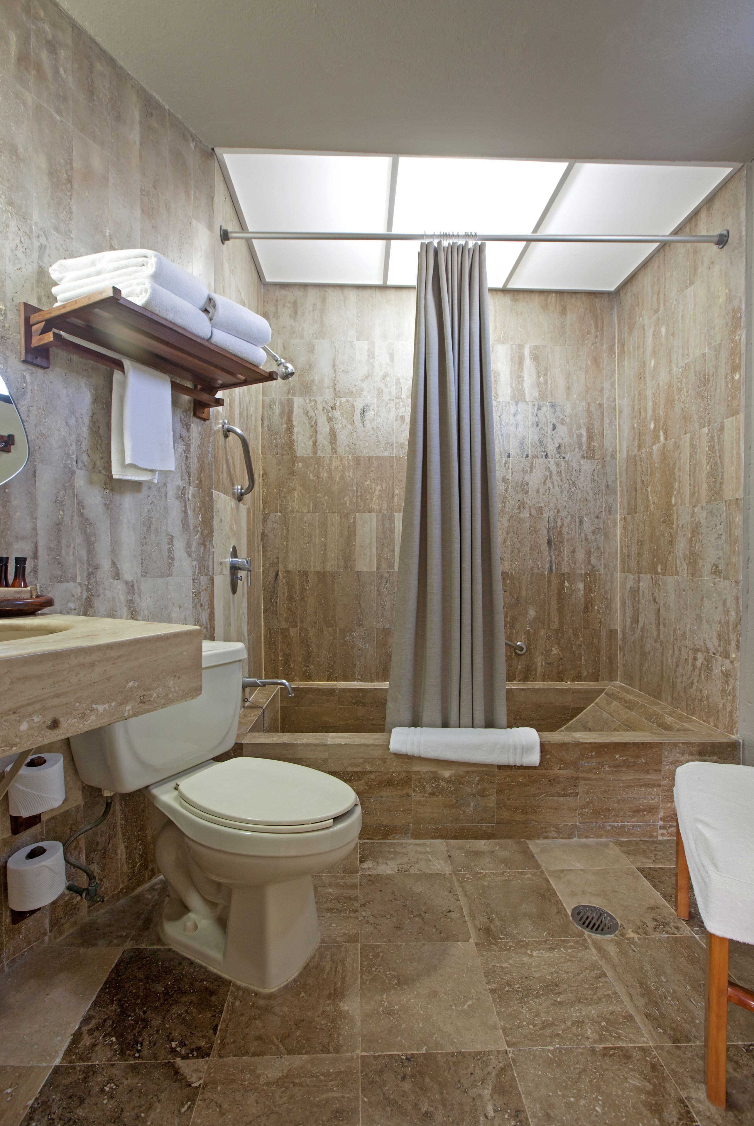 Un bagno con WC, lavandino, doccia e portasciugamani.