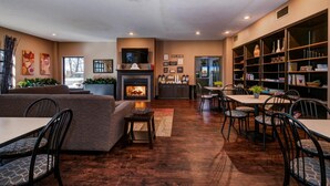 A modern living room with a fireplace, a dining area, and a bookshelf.