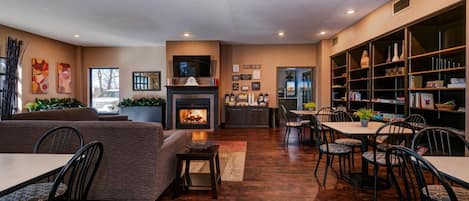 Una sala de estar moderna con chimenea, comedor y estantería.
