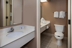 A bathroom with a sink, mirror, toilet, and towel rack.