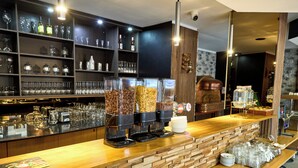 A bar area with coffee dispensers, a wine bottle, and a variety of glasses. - Hotel Europacity (Brussels)