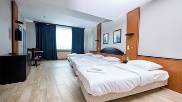 Une chambre d’hôtel avec un grand lit, un bureau, une chaise et un téléviseur.